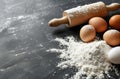 Flour, Eggs, and Rolling Pin on Black Surface