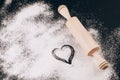 Flour with heart and rolling pin on black Royalty Free Stock Photo