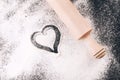 Flour with heart and rolling pin on black Royalty Free Stock Photo