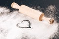 Flour with heart and rolling pin on black Royalty Free Stock Photo