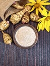 Flour of Jerusalem artichoke in clay bowl on board top