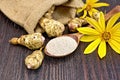 Flour of Jerusalem artichoke in spoon with flower on board