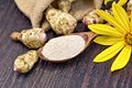 Flour of Jerusalem artichoke in spoon with vegetable on board