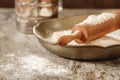 Flour metal bowl with wooden rolling pin on stone table Royalty Free Stock Photo