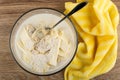 Flour mixture with butter, milk for muffins, spoon in bowl, striped napkin on wooden table. Top view