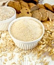 Flour oat and bran in white bowl with bread on board