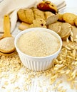 Flour oat in white bowl with bran in spoon on board