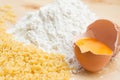 Flour, an open egg and italian pasta