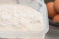 Flour in a plastic bowl close up with some ingredients