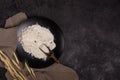 Flour in a plate with a flour scoop. The texture of the black background. Ears of wheat Royalty Free Stock Photo