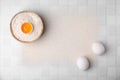 Flour and raw eggs on white tiled table, flat lay