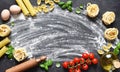 Flour, rolling pin, tomatoes and basil on the table. Pasta cooking process on the kitchen table. Ingredients for making pasta Royalty Free Stock Photo