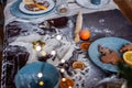 Flour is scattered on wooden Christmas table, gingerbread cookies are being baked. New Years flatlay