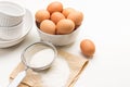 Flour and sieve on paper. Brown chicken eggs in bowl Royalty Free Stock Photo