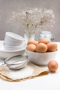 Flour and sieve on paper. The egg is on table. Brown chicken eggs in bowl. White ceramic dishes Royalty Free Stock Photo