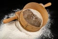 Flour sieved for homemade pastries. Accessories in home kitchen on a dark table