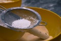 Flour sifting through a metal sieve for a baking. Close up Royalty Free Stock Photo
