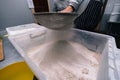 Flour sifting through a sieve for a baking. man hands, industrial