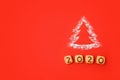 Flour Silhouette Christmas Tree with cookies digits 2020 on red background. Delicious bakery sweet confectionery Christmas card.