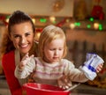 Flour smeared mother and baby making christmas cooki