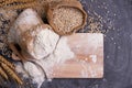 Flour and wheat grains in sacks with wheat ears On a black background table. In a rustic kitchen. Top view