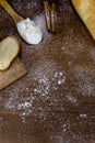 Flour in a wooden spoon  sliced French baguette on a wooden board  and cinnamon sticks sprinkled with flour on a wooden table Royalty Free Stock Photo