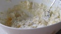 Flouring cottage cheese dough in a white bowl. The process of making curd bagels or croissants