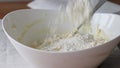 Flouring cottage cheese dough in a white bowl. The process of making curd bagels or croissants