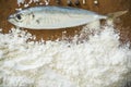 Floury fish on a wooden background