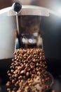 The flow of coffee beans from open flap of the cooling mixer of roasting machine Royalty Free Stock Photo