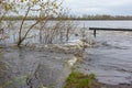 The flow of water on the bank of a wide river during the spring flood on a cloudy day Royalty Free Stock Photo