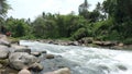 The flow of water in a clear river with a blend of people fishing from the rock Royalty Free Stock Photo