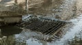 Flow of water during heavy rain and clogging of street sewage. The flow of water during a strong hurricane in storm sewers. Sewage Royalty Free Stock Photo