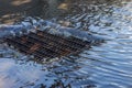 Flow of water during heavy rain and clogging of street sewage. The flow of water during a strong hurricane in storm sewers. Sewage Royalty Free Stock Photo