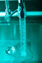 Flow of water in a metal sink on a modern kitchen. Toned Royalty Free Stock Photo