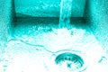 Flow of water in a metal sink on a modern kitchen. Toned Royalty Free Stock Photo