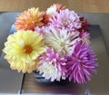 Flower arrangement of an Assortment of Dahlias as decoration on a table with hardwood floor background