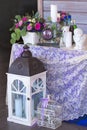 Flower arrangement in a basket decorate the wedding table in purple tones. Vintage. Flowers, candles, clocks. Royalty Free Stock Photo