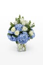 Blue hydrangea and white roses flower arrangement in a large glass vase. Minimal floral design by a florist. Royalty Free Stock Photo