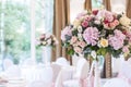 Floral arrangements on white pillars stand on the tables in the restaurant Royalty Free Stock Photo