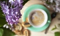 The flower arrangement is made of lilac flowers on a light wooden background with a Cup of coffee Royalty Free Stock Photo