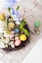 Flower arrangement in a nest with easter eggs on a white table Royalty Free Stock Photo