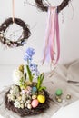 Flower arrangement in a nest with easter eggs on a white table Royalty Free Stock Photo