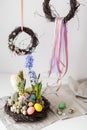 Flower arrangement in a nest with easter eggs on a white table Royalty Free Stock Photo