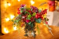 Flower arrangement with red berries, red roses and greens on the table Royalty Free Stock Photo