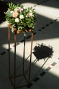 Flower arrangement of roses, eustoma, and other flowers as an element of decor on a golden centerpiece