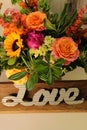 Fall flower arrangement - peach roses, sunflowers, purple flowers, pink and orange vine flowers. LOVE sign