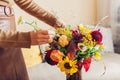 Flower arrangement. Woman makes fall bouquet of sunflowers dahlias roses and zinnias in vase at home. Fall blooms Royalty Free Stock Photo