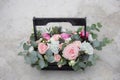 Flower arrangement in a wooden box with spray pink roses, succulent, eustoma, white hypericum, eucaliptus Royalty Free Stock Photo