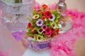Flower arrangements . The cage with flowers stand in restaurant . white roses put on the top of bird cage . Artificial multi-